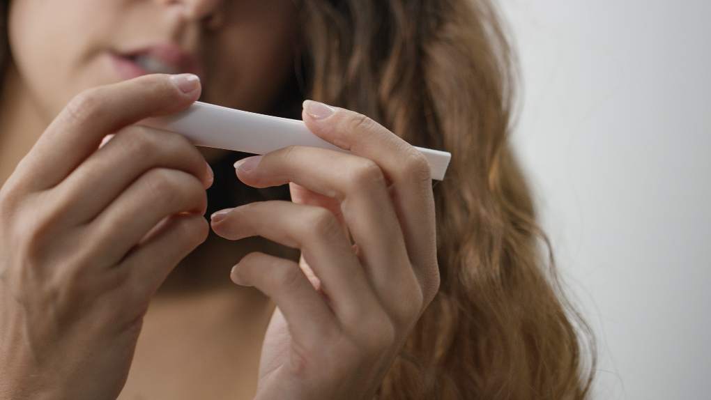 Young woman using home pregnancy test kit